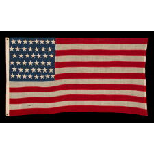 44 STARS IN ZIGZAGGING, STAGGERED ROWS, ON ANTIQUE AMERICAN FLAG WITH SOMEWHAT ELONGATED PROPORTIONS AND STRONG COLORS, MADE IN THE ERA WHEN WYOMING WAS THE MOST RECENT STATE TO JOIN THE UNION, 1890-1896