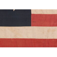 SPECTACULAR ANTIQUE AMERICAN FLAG WITH 38 STARS, ARRANGED IN A RARE VARIANT OF THE "GREAT STAR" PATTERN THAT INCORPORATES STARS BETWEEN EACH ARM; MADE FOR THE 100th ANNIVERSARY OF AMERICAN INDEPENDENCE IN 1876, AMONG THE VERY BEST OF ALL KNOWN EXAMPLES IN THIS STAR COUNT, REFLECTS THE ADDITION OF COLORADO AS THE “CENTENNIAL STATE”