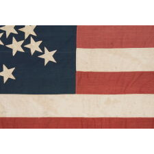 SPECTACULAR ANTIQUE AMERICAN FLAG WITH 38 STARS, ARRANGED IN A RARE VARIANT OF THE "GREAT STAR" PATTERN THAT INCORPORATES STARS BETWEEN EACH ARM; MADE FOR THE 100th ANNIVERSARY OF AMERICAN INDEPENDENCE IN 1876, AMONG THE VERY BEST OF ALL KNOWN EXAMPLES IN THIS STAR COUNT, REFLECTS THE ADDITION OF COLORADO AS THE “CENTENNIAL STATE”