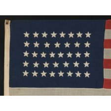 38 STAR FLAG WITH HAND-SEWN STARS, IN AN UNUSUALLY CONFINED PATTERN OF JUSTIFIED ROWS, ON AN ANTIQUE FLAG IN A SMALL SCALE FOR THE PERIOD, 1876-1889, COLORADO STATEHOOD