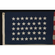 38 STAR FLAG WITH HAND-SEWN STARS, IN AN UNUSUALLY CONFINED PATTERN OF JUSTIFIED ROWS, ON AN ANTIQUE AMERICAN FLAG IN A SMALL SCALE FOR THE PERIOD, 1876-1889, COLORADO STATEHOOD
