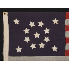 13 STARS WITH SHORT, CONICAL ARMS, ARRANGED IN A MEDALLION CONFIGURATION ON A SMALL SCALE FLAG MADE DURING THE LAST DECADE OF THE 19TH CENTURY, POSSIBLY OF PHILADELPHIA ORIGIN