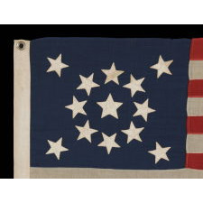 13 STARS ARRANGED IN A MEDALLION PATTERN, WITH A SLIGHTLY LARGER CENTER STAR, ON A SMALL-SCALE ANTIQUE AMERICAN FLAG MARKED "NAVY" [A BRAND NAME], MADE DURING THE LAST DECADE OF THE 19TH CENTURY