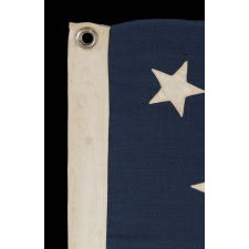 13 STARS ARRANGED IN A MEDALLION PATTERN, WITH A SLIGHTLY LARGER CENTER STAR, ON A SMALL-SCALE ANTIQUE AMERICAN FLAG MARKED "NAVY" [A BRAND NAME], MADE DURING THE LAST DECADE OF THE 19TH CENTURY