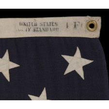 13 STARS ARRANGED IN A 3-2-3-2-3 PATTERN ON A SMALL-SCALE ANTIQUE AMERICAN FLAG MARKED "UNITED STATES ARMY STANDARD BUNTING", CA 1896 - 1908