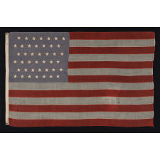 42 HAND-SEWN STARS ON SMALL SCALE FLAG WITH A DUSTY BLUE CANTON, AN UNOFFICIAL STAR COUNT, WASHINGTON STATEHOOD, 1889-1890