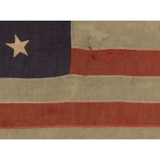 13 STARS IN A MEDALLION CONFIGURATION ON A SMALL-SCALE ANTIQUE AMERICAN FLAG OF THE 1890-1900 ERA, WITH AMPLE WEAR AND LOSSES