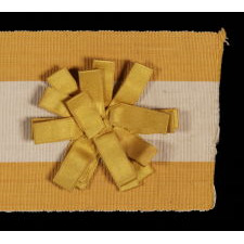 SILK SUFFRAGETTE SASH RIBBON IN YELLOW & WHITE WITH "VOTES FOR WOMEN" TEXT AND A SATIN RIBBON ROSETTE, 1910-1915