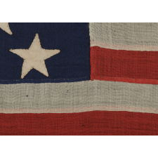 13 HAND-SEWN, SINGLE-APPLIQUÉD STARS, LIKELY MADE BY ANNIN & CO. IN NEW YORK CITY, IN A RARE, SMALL SIZE AMONG KNOWN FLAGS WITH SEWN CONSTRUCTION, 1861-1876 ERA, PROBABLY DESIGNED FOR USE AS A CAMP COLORS OR IN SOME OTHER MILITARY FUNCTION