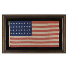 32 STAR ANTIQUE AMERICAN FLAG, REPRESENTING MINNESOTA STATEHOOD, 1858-59, IN A STYLE KNOWN TO HAVE SEEN MILITARY SERVICE DURING THE FORTHCOMING CIVIL WAR (1861-65) AND BEARING THE SIGNATURE OF A SOLDIER WHO FOUGHT WITH THE 15TH MICHIGAN INFANTRY, POSSIBLY MADE BY THE ANNIN COMPANY IN NEW YORK CITY