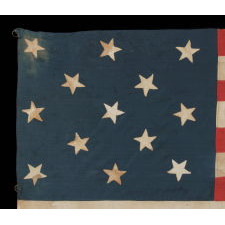 13 HAND-SEWN STARS ARRANGED IN A 3-2-3-2-3 PATTERN, WITH VARYING VERTICAL ORIENTATION, ON A HOMEMADE ANTIQUE AMERICAN FLAG DATING TO THE ERA OF THE 1876 CENTENNIAL OF AMERICAN INDEPENDENCE