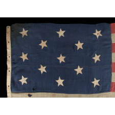 13 HAND-SEWN STARS IN A 3-2-3-2-3 CONFIGURATION OF LINEAL ROWS, ON A LARGE SCALE ANTIQUE AMERICAN FLAG WITH A STENCILED SIGNATURE ALONG THE HOIST THAT READS "GEO L. WRIGHT. BOYLSTON. MA.", PROBABLY MADE FOR THE 100-YEAR ANNIVERSARY OF AMERICAN INDEPENDENCE IN 1876