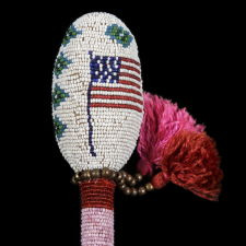 ASSINIBOINE (STONE SIOUX) BEADED DRUM STICK, A GREAT FORM WITH AMERICAN FLAG IMAGERY, CA 1890, GROS VENTRE REGION