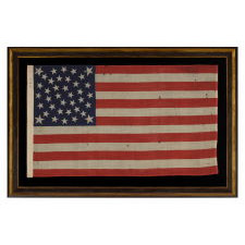 38 STARS ON AN EXTRAORDINARY ANTIQUE FLAG MADE FOR THE 1876 CENTENNIAL EXPOSITION, LIKELY BY THE HORSTMANN COMPANY IN PHILADELPHIA, WITH AN EXTREMELY RARE FORM OF THE MEDALLION CONFIGURATION THAT BEARS AN ELLIPSE OF 6 STARS IN THE CENTER AND A LARGE STAR IN EACH CORNER; REFLECTS COLORADO STATEHOOD
