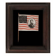 EXTREMELY RARE ABRAHAM LINCOLN MOURNING FLAG, WITH HIS PORTRAIT IN THE STRIPED FIELD, ON ITS ORIGINAL STAFF; PRINTED ON PAPER, SIGNED “LYBRAND,” 1865
