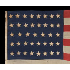 39 STARS ON AN ANTIQUE AMERICAN FLAG WITH HAND-SEWN, SINGLE-APPLIQUÉD STARS, MADE BY ANNIN IN NEW YORK CITY, DATING TO THE 1876 CENTENNIAL OF AMERICAN INDEPENDENCE, NEVER AN OFFICIAL STAR COUNT, REFLECTS THE ANTICIPATED ARRIVAL OF COLORADO AND THE DAKOTA TERRITORY