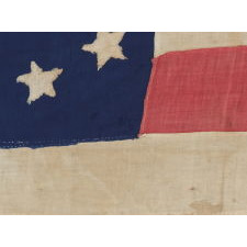 34 STARS IN AN OUTSTANDING OVAL MEDALLION CONFIGURATION, ON A NARROW CANTON THAT RESTS ON THE 6TH STRIPE, A HOMEMADE, ANTIQUE AMERICAN FLAG OF THE CIVIL WAR PERIOD, ENTIRELY HAND-SEWN, 1861-63, KANSAS STATEHOOD