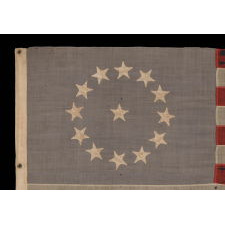 13 STARS IN A CIRCULAR VERSION OF THE 3RD MARYLAND PATTERN, ON A SMALL SCALE FLAG MADE IN THE PERIOD BETWEEN ROUGHLY 1885 AND 1895, WITH A DUSTY BLUE CANTON AND WITH STRIKING VISUAL PRESENTATION FROM LONG-TERM USE