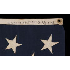 13 STARS ARRANGED IN A 3-2-3-2-3 PATTERN ON A SMALL-SCALE ANTIQUE AMERICAN FLAG MARKED "UNITED STATES ARMY STANDARD BUNTING", CA 1895 - 1910