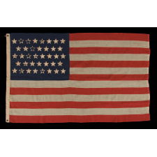 38 STARS WITH ENDEARING WEAR ON AN UNUSUALLY SMALL PIECED-AND SEWN ANTIQUE AMERICAN FLAG OF THE 1876-1889 PERIOD, REFLECTS COLORADO'S ADDITION TO THE UNION