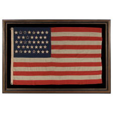 38 STARS WITH ENDEARING WEAR ON AN UNUSUALLY SMALL PIECED-AND SEWN ANTIQUE AMERICAN FLAG OF THE 1876-1889 PERIOD, REFLECTS COLORADO'S ADDITION TO THE UNION