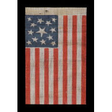 13 STAR AMERICAN PARADE FLAG MADE BETWEEN THE CIVIL WAR (1861-65) AND THE 1876 CENTENNIAL OF AMERICAN INDEPENDENCE, FEATURING THREE SIZES OF WHIMSICALLY SHAPED STARS IN A MEDALLION CONFIGURATION