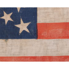 31 STARS ON AN ANTIQUE AMERICAN FLAG WITH ITS STARS CONFIGURED IN A MEDALLION PATTERN THAT FEATURES A LARGE, HALOED CENTER STAR; REFLECTS THE PERIOD WHEN CALIFORNIA HAD RECENTLY BECOME THE 31ST STATE TO ENTER THE UNION, 1850-1858