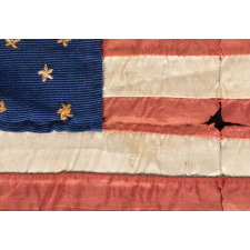34 NEEDLEWORK STARS ON A TINY, HAND-SEWN, SILK AMERICAN FLAG, AT ONE TIME SEWN INTO A QUILT MADE DURING THE OPENING YEARS OF THE CIVIL WAR, 1861-63, REFLECTS KANSAS STATEHOOD