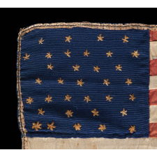 34 NEEDLEWORK STARS ON A TINY, HAND-SEWN, SILK AMERICAN FLAG, AT ONE TIME SEWN INTO A QUILT MADE DURING THE OPENING YEARS OF THE CIVIL WAR, 1861-63, REFLECTS KANSAS STATEHOOD