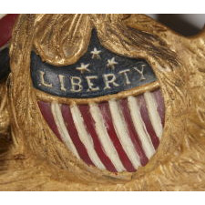 CARVED EAGLE BY GEORGE STAPF, HARRISBURG, PENNSYLVANIA, AN UNUSUALLY FINE EXAMPLE WITH A STAR IN ITS BEAK AND A SHIELD IN RELIEF ON ITS BREAST WITH THE WORD "LIBERTY," FEATURES UNIQUE TO THIS CARVING, 1890-WWI