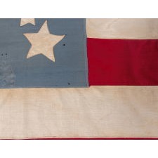 34 STARS IN A WHIMSICAL RENDITION OF THE GREAT STAR PATTERN, ON A CIVIL WAR PERIOD FLAG WITH A CORNFLOWER BLUE CANTON, UPDATED TO 39 STARS IN 1876