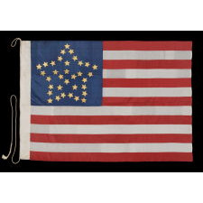34 GILT PAINTED STARS IN A BOLD REPRESENTATION OF THE “GREAT STAR” PATTERN, ON A SILK, ANTIQUE AMERICAN FLAG MADE DURING THE OPENING YEARS OF THE CIVIL WAR, 1861-63, PROBABLY MADE UNDER MILITARY CONTRACT OR FOR USE BY LOCAL MILITIA, ENTIRELY HAND-SEWN, IN A TINY SCALE FOR THE PERIOD