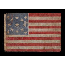13 STARS IN A MEDALLION PATTERN ON AN ANTIQUE AMERICAN PARADE FLAG, MADE FOR THE 1876 CENTENNIAL OF AMERICAN INDEPENDENCE; AN EXTREMELY SCARCE EXAMPLE WITH NICE FOLK QUALITIES