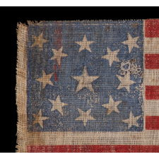 13 STARS IN A MEDALLION PATTERN ON AN ANTIQUE AMERICAN PARADE FLAG, MADE FOR THE 1876 CENTENNIAL OF AMERICAN INDEPENDENCE; AN EXTREMELY SCARCE EXAMPLE WITH NICE FOLK QUALITIES
