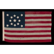 13 SLIGHTLY BULBOUS STARS IN A MEDALLION CONFIGURATION, WITH A LARGE CENTER STAR, ON A SMALL-SCALE ANTIQUE AMERICAN FLAG MADE DURING THE LAST DECADE OF THE 19TH CENTURY, CA 1890-1895