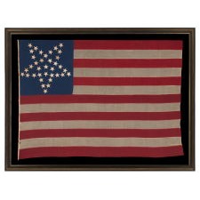 36 STARS IN THE "GREAT STAR" OR "GREAT LUMINARY" PATTERN, ON A MERINO WOOL FLAG OF THE CIVIL WAR ERA WITH BEAUTIFUL SCARLET AND ROYAL BLUE COLOR AND WITH ITS CANTON RESTING ON THE "WAR STRIPE," REFLECTS NEVADA STATEHOOD, 1864-67