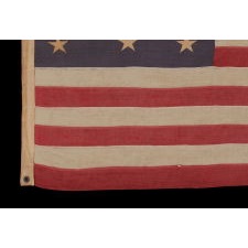 13 STARS IN A 3-2-3-2-3 PATTERN ON A DUSTY BLUE CANTON, ON A SMALL-SCALE, ANTIQUE AMERICAN FLAG WITH AN ELONGATED PROFILE, MADE DURING THE LAST DECADE OF THE 19TH CENTURY, CA 1890-1895