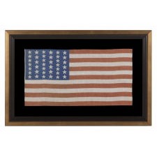 39 STARS IN TWO SIZES, ALTERNATING FROM ONE COLUMN TO THE NEXT, ON AN ANTIQUE AMERICAN PARADE FLAG WITH AN UNUSUALLY ELONGATED PROFILE, DATING TO THE 1876 CENTENNIAL, NEVER AN OFFICIAL STAR COUNT, REFLECTS THE ANTICIPATED ARRIVAL OF COLORADO AND THE DAKOTA TERRITORY