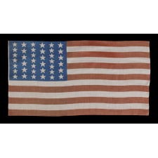 39 STARS IN TWO SIZES, ALTERNATING FROM ONE COLUMN TO THE NEXT, ON AN ANTIQUE AMERICAN PARADE FLAG WITH AN UNUSUALLY ELONGATED PROFILE, DATING TO THE 1876 CENTENNIAL, NEVER AN OFFICIAL STAR COUNT, REFLECTS THE ANTICIPATED ARRIVAL OF COLORADO AND THE DAKOTA TERRITORY