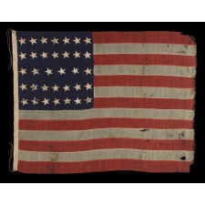34 STARS ON AN ANTIQUE AMERICAN FLAG MADE DURING THE OPENING YEARS OF THE CIVIL WAR, WITH SPLENDID PRESENTATION RESULTING FROM THE ENDEARING CHARACTERISTICS OF LONG-TERM USE, POSSIBLY FIELD-CARRIED BY A UNION REGIMENT, CA 1861-63, KANSAS STATEHOOD