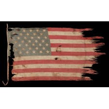 39 TUMBLING STARS IN STAGGERED ROWS ON AN ANTIQUE AMERICAN FLAG WITH A GHOSTLY PRESENTATION FROM EXTENSIVE WEAR, MADE DURING THE ERA OF THE 1876 CENTENNIAL OF AMERICAN INDEPENDENCE, NEVER AN OFFICIAL STAR COUNT, REFLECTS THE ANTICIPATED ARRIVAL OF THE DAKOTA TERRITORY AS A SINGLE STATE
