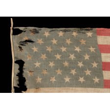 39 TUMBLING STARS IN STAGGERED ROWS ON AN ANTIQUE AMERICAN FLAG WITH A GHOSTLY PRESENTATION FROM EXTENSIVE WEAR, MADE DURING THE ERA OF THE 1876 CENTENNIAL OF AMERICAN INDEPENDENCE, NEVER AN OFFICIAL STAR COUNT, REFLECTS THE ANTICIPATED ARRIVAL OF THE DAKOTA TERRITORY AS A SINGLE STATE
