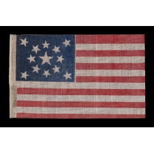 13 STARS IN A MEDALLION PATTERN ON AN ANTIQUE AMERICAN PARADE FLAG MADE FOR THE 1876 CENTENNIAL CELEBRATION; A LARGE EXAMPLE AMONG ITS COUNTERPARTS OF THE PERIOD
