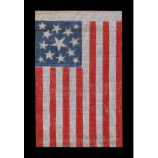 13 STAR AMERICAN PARADE FLAG MADE BETWEEN THE CIVIL WAR (1861-65) AND THE 1876 CENTENNIAL OF AMERICAN INDEPENDENCE, FEATURING THREE SIZES OF WHIMSICALLY SHAPED STARS IN A MEDALLION CONFIGURATION