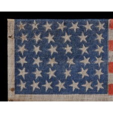ANTIQUE 38 STAR FLAG WITH STRONG COLORATION AND ESPECIALLY FOLKY STARS, PRINTED ON A COTTON AND FLAX BLENDED FABRIC WITH A CRUDE WEAVE, COLORADO STATEHOOD, 1876-1889