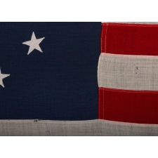 13 STARS IN A CIRCULAR VERSION OF THE 3RD MARYLAND PATTERN, ON AN ESPECIALLY ATTRACTIVE, SMALL SCALE, ANTIQUE AMERICAN FLAG, MADE IN THE 1890's-1910 ERA
