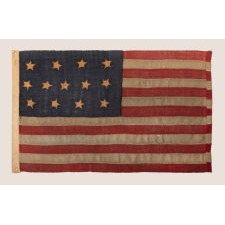 ONE OF THE EARLIEST 13 STAR ANTIQUE AMERICAN FLAGS THAT ONE WILL EVER ENCOUNTER, CIRCA 1820's-1840's, ENTIRELY HAND-SEWN, WITH SINGLE-APPLIQUÉD STARS IN A 4-5-4 ARRANGEMENT, TINY IN SCALE AMONG ITS COUNTERPARTS