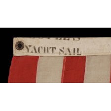 13 STARS IN A 3-2-3-2-3 LINEAL CONFIGURATION ON AN ANTIQUE AMERICAN FLAG MADE IN NEW YORK CITY BY JOHN BOYLE & COMPANY, CA 1885-1900, WITH AN UNUSUAL, BLACK-INKED STENCIL ALONG THE HOIST THAT READS “BOYLE’S YACHT SAIL”