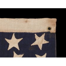 34 HAPHAZARDLY PLACED, HAND-SEWN STARS, IN CRUDE LINEAL ROWS, ON AN ANTIQUE AMERICAN FLAG OF THE CIVIL WAR PERIOD WITH HAND-SEWN STRIPES AND IN A TINY SCALE AMONG ITS COUNTERPARTS, 1861-1863, REFLECTS THE ADDITION OF KANSAS AS THE 34TH STATE