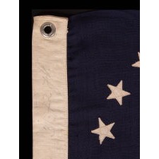 ANTIQUE AMERICAN PRIVATE YACHT FLAG (ENSIGN) WITH 13 STARS SURROUNDING A CANTED ANCHOR, AN ATTRACTIVE, ELONGATED EXAMPLE WITH AN OFF-SET DEVICE, CIRCA 1905 – 1920